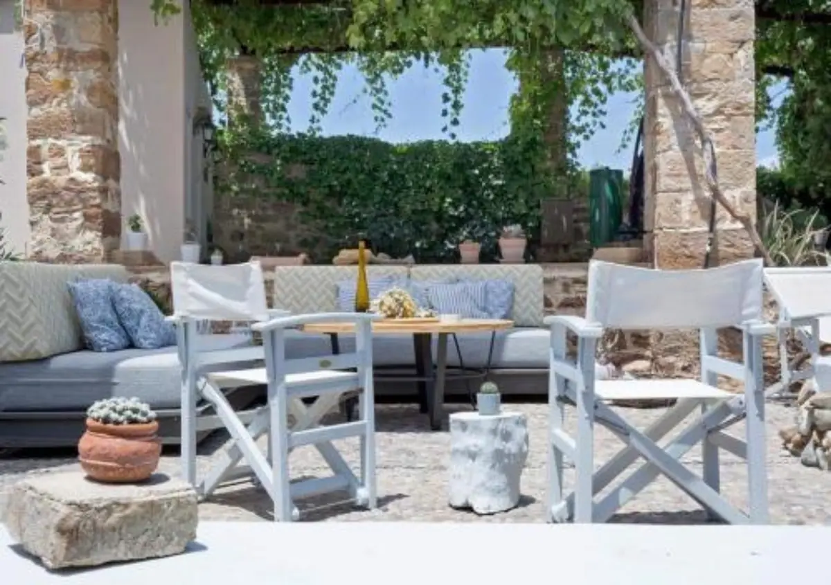Shaded courtyard seating beneath stone arches at Voulamandis House in Kampos, Chios